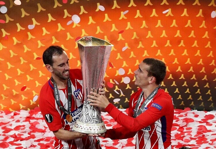 Antoine Griezmann and Gabi lifting the Europa League trophy after Atletico's win against Marseille